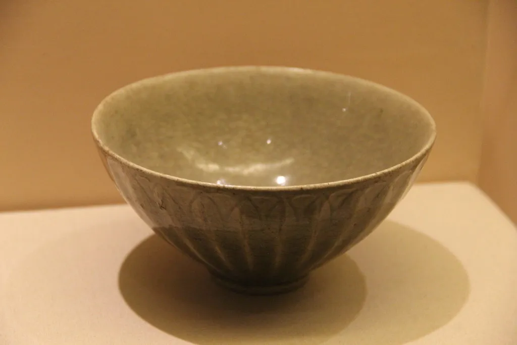 Celadon-glazed ceramic bowl with carved petal pattern